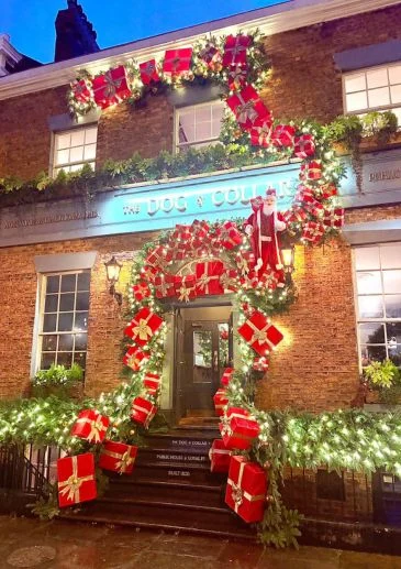 The Dog and Collar pub in Liverpool entrance decorated with christmas pine, red presents and a moving father Christmas by Booker Flowers and Gifts